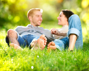 Fototapeta premium Park. Young Couple Lying on Grass Outdoor