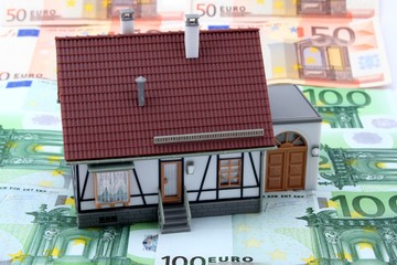 Haus mit Garage steht auf Geldscheinen