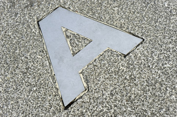 Background texture letter A to steel embedded in granite floor