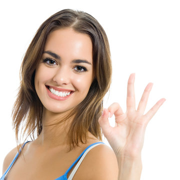Portrait of smiling woman with OK sign, over white