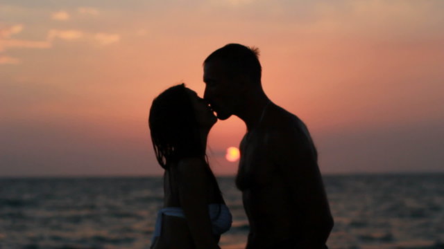 Couple silhouette at the beach. Sunset light.