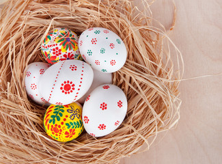 Easter eggs in nest on rustic wooden planks