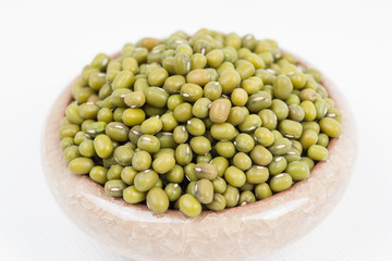 Green mung beans in bowl on white background