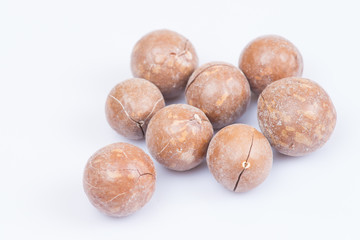 unshelled macadamia nuts on white background