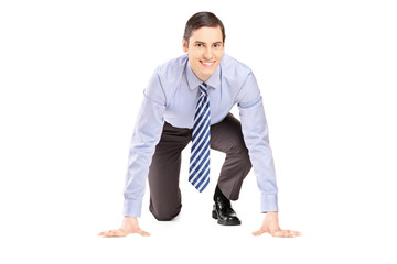 A smiling businessman ready to run isolated on white background