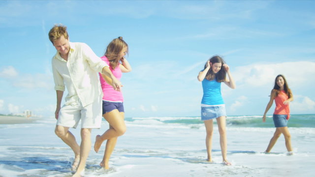 Happy Caucasian Family Walking Outdoors Wet Sand on Beach