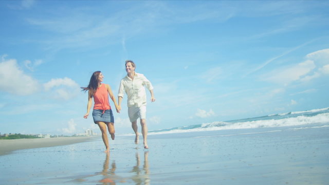 Happy Caucasian Couple Running on Beach