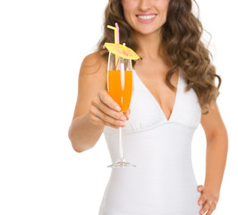 Fototapeta premium Closeup on young woman in swimsuit giving cocktail