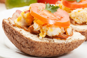 Sandwich with scrambled eggs and bacon. Selective focus.