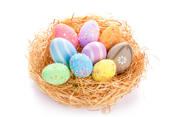 Colorful Easter eggs in the nest over white background