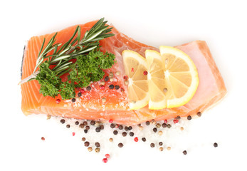 Fresh salmon fillet with herbals and lemon slices, isolated
