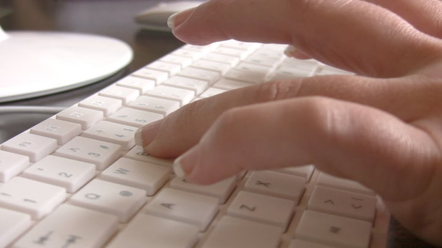 Close up of a hand typing on keyboard.