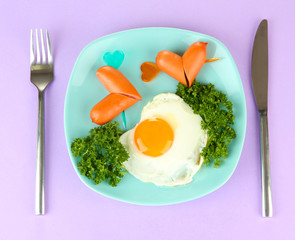 Sausages in form of hearts, scrambled eggs and parsley,