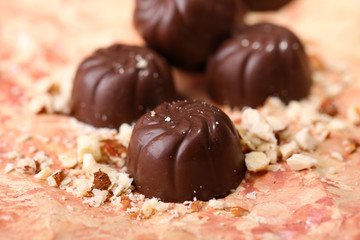 Chocolate candies with nuts, on color background