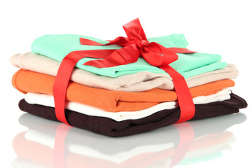Pile of clothing with red ribbon and bow isolated on white
