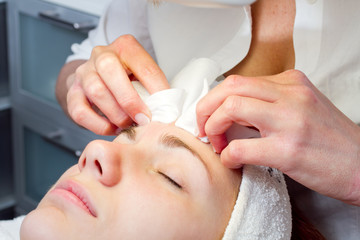 young woman having facial beauty treatment at beauty salon
