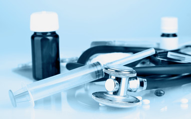 Fototapeta premium Medicines and stethoscope in blue light