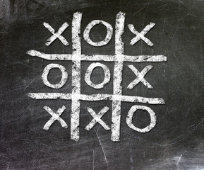 Noughts and crosses drawn on a chalkboard.
