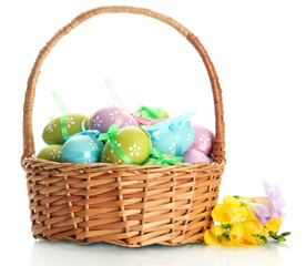 Bright easter eggs with bows in basket, isolated on white