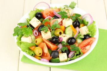 Fresh salad in plate on wooden table