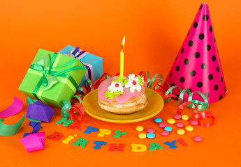 Colorful birthday cake with candle and gifts