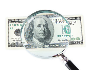 Hundred dollar bill and magnifying glass isolated on white