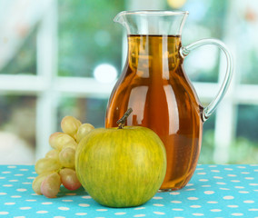 Apple juice in pitcher on table in room