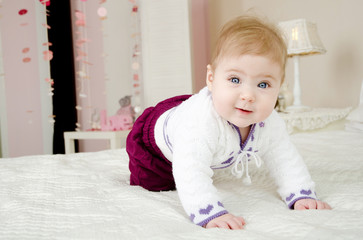 Naklejka premium Little girl on the bed, looking at the camera