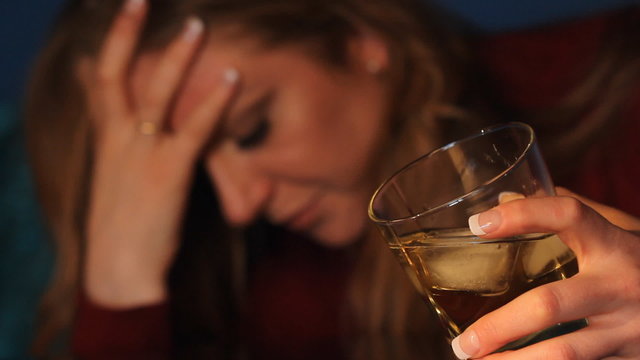 Woman drinking alcohol. Glass in sharp focus.