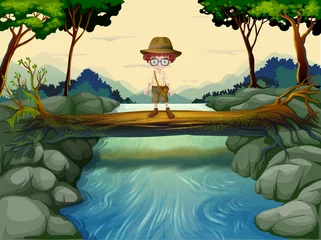 Foto auf Acrylglas Ein Junge steht über dem Baumstamm am Fluss © GraphicsRF