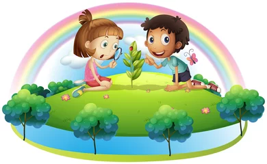 Fotobehang Een meisje en een jongen kijken naar de plant © GraphicsRF