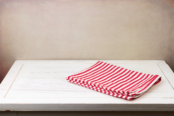 Background with white wooden table and red striped tablecloth