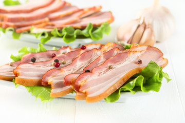 Bacon with pepper on white wooden