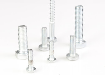Seven silver metal screws isolated on white background.