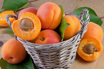 fresh apricot in wicker basket on wooden background
