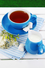 Beautiful tea composition on wooden picnic table close-up