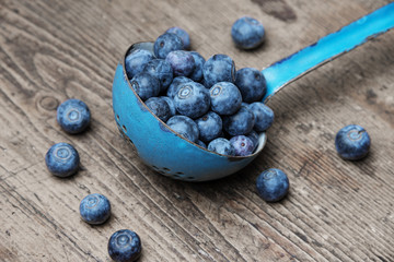 a ladle with blueberries on a table