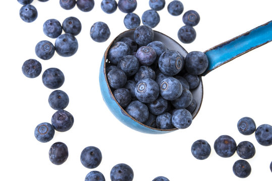 a ladle with blueberries on white background