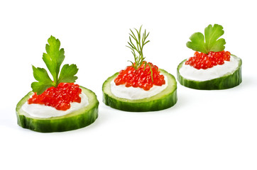 Red caviar on a green cucumber, isolated over white