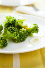 stewed pieces of broccoli on a white dish