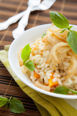 risotto with pumpkin and onion in a white bowl,