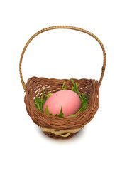 Pink easter egg in a basket with grass
