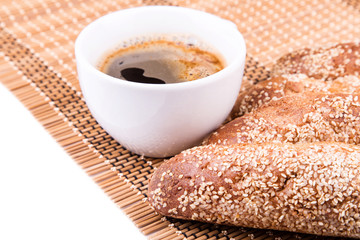 Freshly baked bread rolls with sesame with cup of coffee