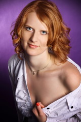 Fototapeta premium Redhead in a open white shirt on a violet background