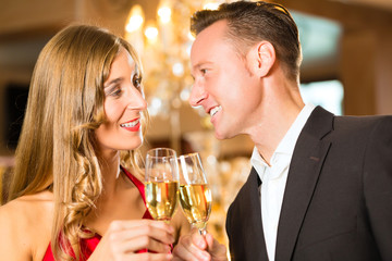 Man and woman tasting Champagne in restaurant