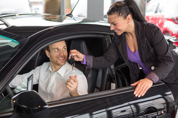 Fototapeta na wymiar Sprzedawczyni sprzedaży samochodu do szczęśliwego klienta