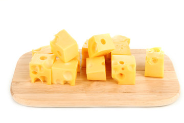 Cheese cubes on wooden board isolated on white