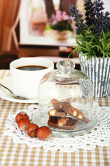 Chocolate pieces under glass cover and hot drink