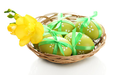 Bright easter eggs with bows in basket, isolated on white