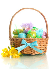 Bright easter eggs with bows in basket, isolated on white